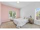 A naturally lit bedroom with a pale pink accent wall and decorative throw pillows at 4465 W Woodbridge Ln, New Palestine, IN 46163