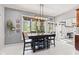 Bright dining area featuring a modern chandelier, large windows, and view of the well maintained backyard at 4465 W Woodbridge Ln, New Palestine, IN 46163