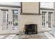 Stone fireplace with a wooden mantel and hearth, flanked by two sets of french doors at 4465 W Woodbridge Ln, New Palestine, IN 46163