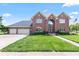 Stunning two-story brick home featuring a three-car garage and well-manicured front lawn at 4465 W Woodbridge Ln, New Palestine, IN 46163