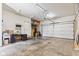 Bright garage with a roll-up door, a desk area, and an adjacent access door at 4465 W Woodbridge Ln, New Palestine, IN 46163