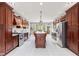 Spacious kitchen features custom wood cabinetry, stainless steel appliances, and an island with seating at 4465 W Woodbridge Ln, New Palestine, IN 46163