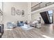 Bright living room featuring two-story ceiling, multiple couches, and hardwood floors at 4465 W Woodbridge Ln, New Palestine, IN 46163