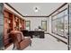 This is a home office with custom built-in shelving, large window and leather chair at 4465 W Woodbridge Ln, New Palestine, IN 46163
