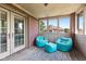 Bright sunroom with playful teal seating and lots of light at 4465 W Woodbridge Ln, New Palestine, IN 46163