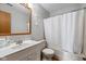This bathroom has a sink, toilet, tub, and shower with a white shower curtain and a mirror hanging on the wall at 4609 Framington Ct, Indianapolis, IN 46254