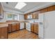 Functional kitchen with wood cabinets, white appliances, and a sunny window overlooking the yard at 4609 Framington Ct, Indianapolis, IN 46254