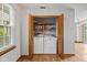 Laundry area features a side-by-side washer and dryer with open storage shelves above at 4609 Framington Ct, Indianapolis, IN 46254