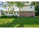Backyard view featuring a brick and vinyl home with a well-maintained lawn and trees at 5081 N 500 W, Fairland, IN 46126