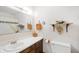 Well-lit bathroom with wood vanity, sink, toilet, mirror, and decorative shelving at 5081 N 500 W, Fairland, IN 46126