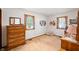 Well-lit bedroom featuring a wooden dresser, two windows, and neutral carpet at 5081 N 500 W, Fairland, IN 46126
