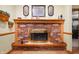 Close-up of a brick fireplace with a wooden mantle, decor, and an ornate brass screen at 5081 N 500 W, Fairland, IN 46126