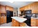 Bright kitchen with light wood cabinets, black appliances, and a central island with stool at 5081 N 500 W, Fairland, IN 46126