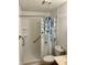Bathroom with white shower, white tiles, shower safety bar and patterned curtain at 5453 David St, Indianapolis, IN 46226