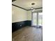Dining area with wood floors, modern lighting fixture, dark wainscoting, and sliding glass doors at 5453 David St, Indianapolis, IN 46226
