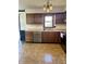 Functional kitchen boasting dark-stained cabinetry, tile floors, and ample counter space at 5453 David St, Indianapolis, IN 46226