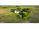 An aerial shot of a farm with a unique collection of buildings surrounded by lush, cultivated fields under a bright sky at 6012 N 200 W, Greenfield, IN 46140