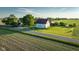 Aerial view of a traditional farm barn with blue accents and a surrounding cornfield during a vibrant, sunny day at 6012 N 200 W, Greenfield, IN 46140