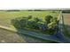 A picturesque aerial shot shows a well-kept rural home, complete with lush trees, a charming fence, and extensive fields at 6012 N 200 W, Greenfield, IN 46140