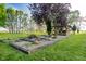 Outdoor fire pit area with timbered enclosure and a beautiful view of the spacious backyard at 6012 N 200 W, Greenfield, IN 46140