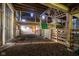 Large barn interior with stalls, hay floor, and wooden beams, offering rustic charm at 6012 N 200 W, Greenfield, IN 46140