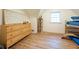 Bedroom featuring a wooden dresser, book shelves, and a bunk bed with bright natural light from the window at 6012 N 200 W, Greenfield, IN 46140