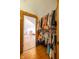 Closet with hanging clothes, leading to bedroom with wood-look flooring, and bright natural light at 6012 N 200 W, Greenfield, IN 46140