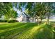 Charming home exterior featuring manicured lawn, grey siding, mature trees, and a classic design at 6012 N 200 W, Greenfield, IN 46140