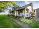 Charming home with a covered porch, inviting garden, and lush green lawn and stone walkway at 6012 N 200 W, Greenfield, IN 46140