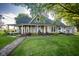 Charming home featuring a wraparound porch, lush lawn, and meticulous landscaping creating curb appeal at 6012 N 200 W, Greenfield, IN 46140