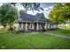 Inviting home with a covered porch, adorned with classic columns and a picturesque landscape at 6012 N 200 W, Greenfield, IN 46140