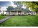 Charming home with a covered porch, white rocking chairs, a well-manicured lawn, and a stone walkway at 6012 N 200 W, Greenfield, IN 46140