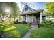 A cozy front porch with an overhang, lush greenery, and a stone pathway leading to the entrance at 6012 N 200 W, Greenfield, IN 46140