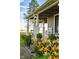 Inviting front porch with classic columns, a white rocking chair, and vibrant flowers lining the walkway at 6012 N 200 W, Greenfield, IN 46140