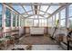 Cozy greenhouse interior with a sofa, rug, piano, and potted plants at 6012 N 200 W, Greenfield, IN 46140