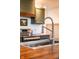 Close-up view of a stainless steel sink and faucet in a kitchen with painted cabinets and wood countertops at 6012 N 200 W, Greenfield, IN 46140