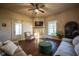 Comfortable living room featuring a fireplace, ceiling fan, hardwood floors, and large windows at 6012 N 200 W, Greenfield, IN 46140