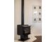 Close-up of a wood burning stove and decorative wall art at 6012 N 200 W, Greenfield, IN 46140