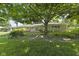 Spacious backyard featuring a stone home exterior, a large shade tree, and a green lawn at 618 Mellowood Dr, Indianapolis, IN 46217