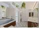 This bathroom features a tub, shower, dual sinks, decorative plants and ample lighting at 618 Mellowood Dr, Indianapolis, IN 46217