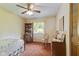 Cozy bedroom with patterned wallpaper, wooden furniture, ceiling fan and natural light from the window at 618 Mellowood Dr, Indianapolis, IN 46217
