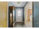 Cozy foyer featuring slate flooring, floral wallpaper, and a classic grandfather clock at 618 Mellowood Dr, Indianapolis, IN 46217
