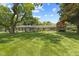 Ranch home with stone accents, mature trees, manicured lawn, and blue skies at 618 Mellowood Dr, Indianapolis, IN 46217
