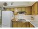 Kitchen with a gas stovetop, white refrigerator, and plenty of cabinet storage at 618 Mellowood Dr, Indianapolis, IN 46217