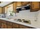 A kitchen featuring a sink, stovetop, and white-tiled backsplash at 618 Mellowood Dr, Indianapolis, IN 46217