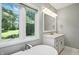 Bright bathroom features a soaking tub under a window and a vanity with double sinks at 6183 Whitetail Run, Greenwood, IN 46143