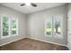 Bedroom with neutral carpet and two windows offering views of the surrounding greenery at 6183 Whitetail Run, Greenwood, IN 46143