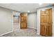 Bedroom with plush carpeting and wood door, offering access to adjoining rooms at 6183 Whitetail Run, Greenwood, IN 46143