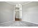 A gray dining room featuring a chandelier, gray carpet, and trim throughout at 6183 Whitetail Run, Greenwood, IN 46143