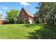 Spacious backyard showcasing lush lawn, mature trees, and attached garage, perfect for outdoor activities at 6183 Whitetail Run, Greenwood, IN 46143